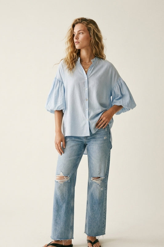 Q2 Blusa azzurra con maniche a sbuffo e bottoni sul retro
