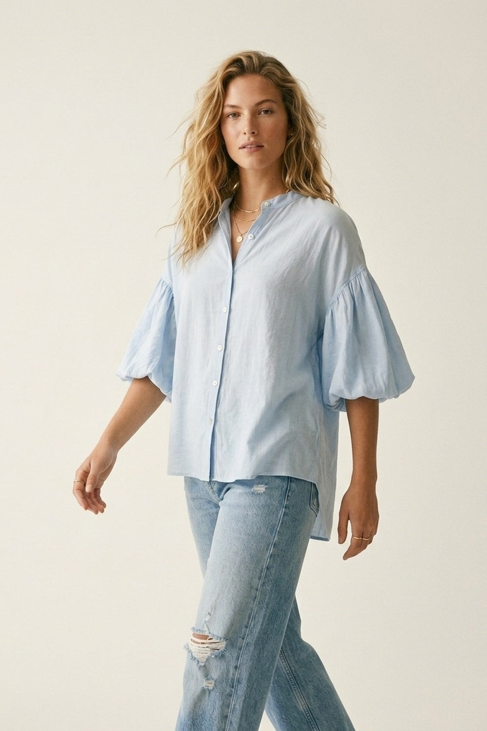 Blusa azzurra con maniche a sbuffo e bottoni sul retro