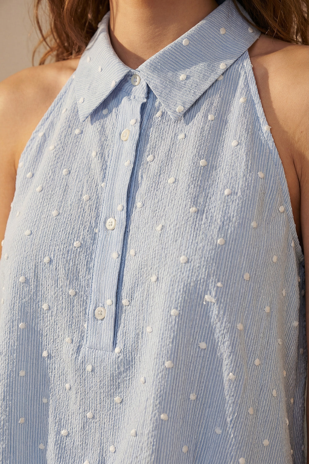 Blusa azzurra ricamata a pois con bottoni