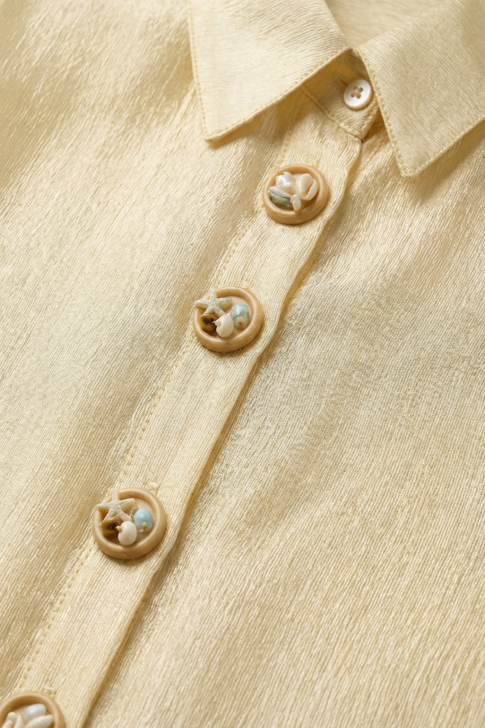 blusa beige in tessuto brillante con bottoni retrò