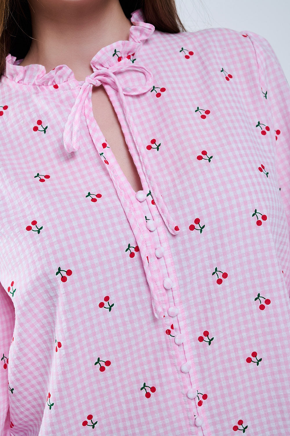 Camicetta rosa con dettagli di ciliegie e fiocco legato
