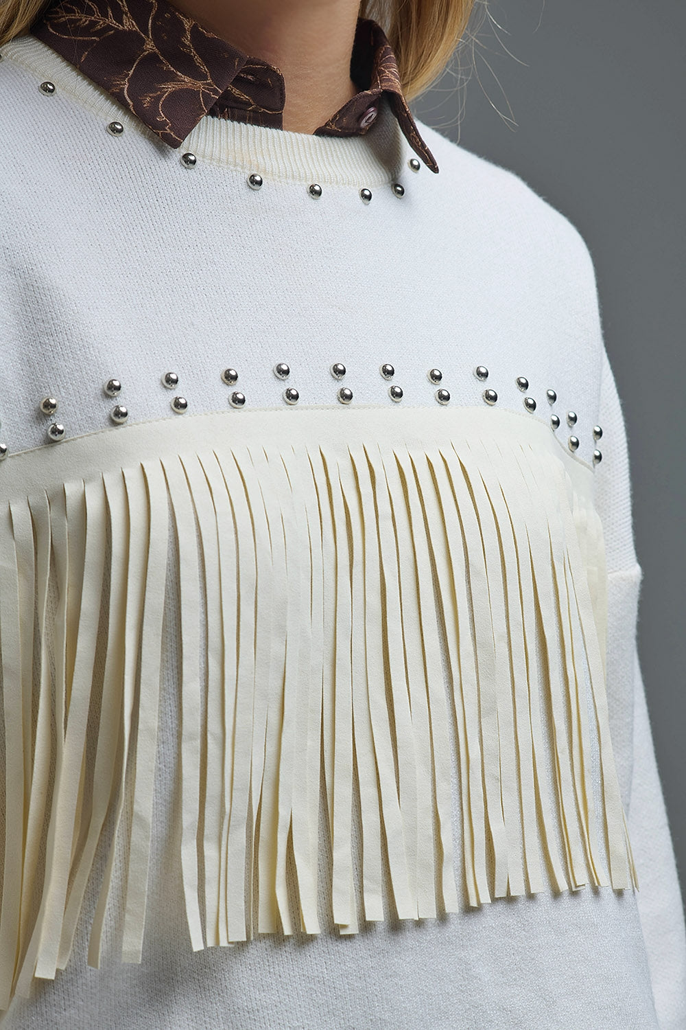 Elegante maglione bianco lavorato a maglia con frange