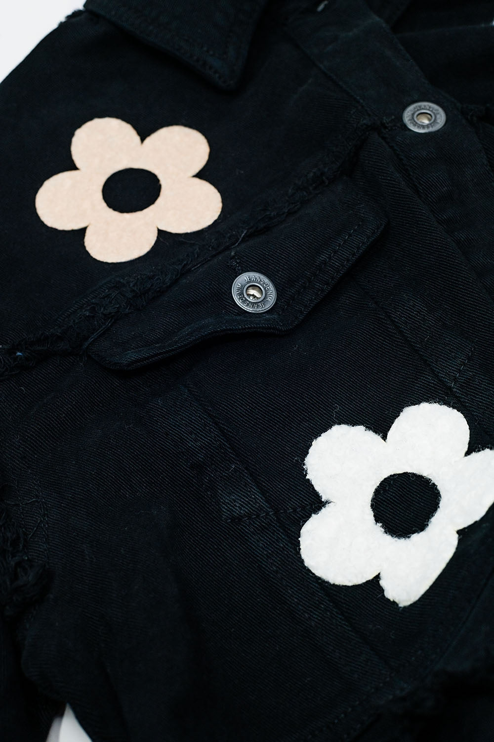 Giacca cropped con tasche sul petto e dettagli floreali in nero