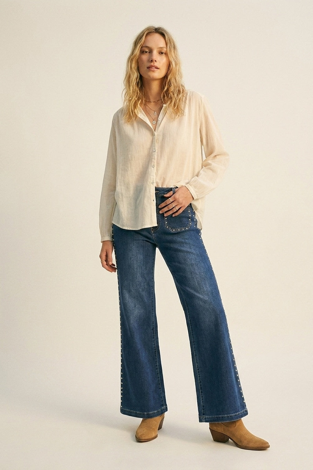 jeans di denim blu a zampa con dettagli di borchie laterali