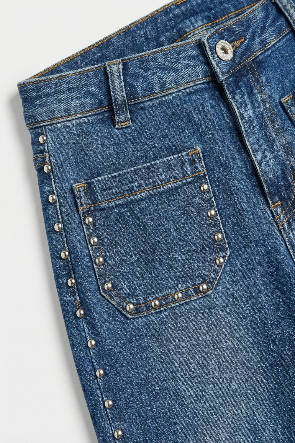 jeans di denim blu a zampa con dettagli di borchie laterali