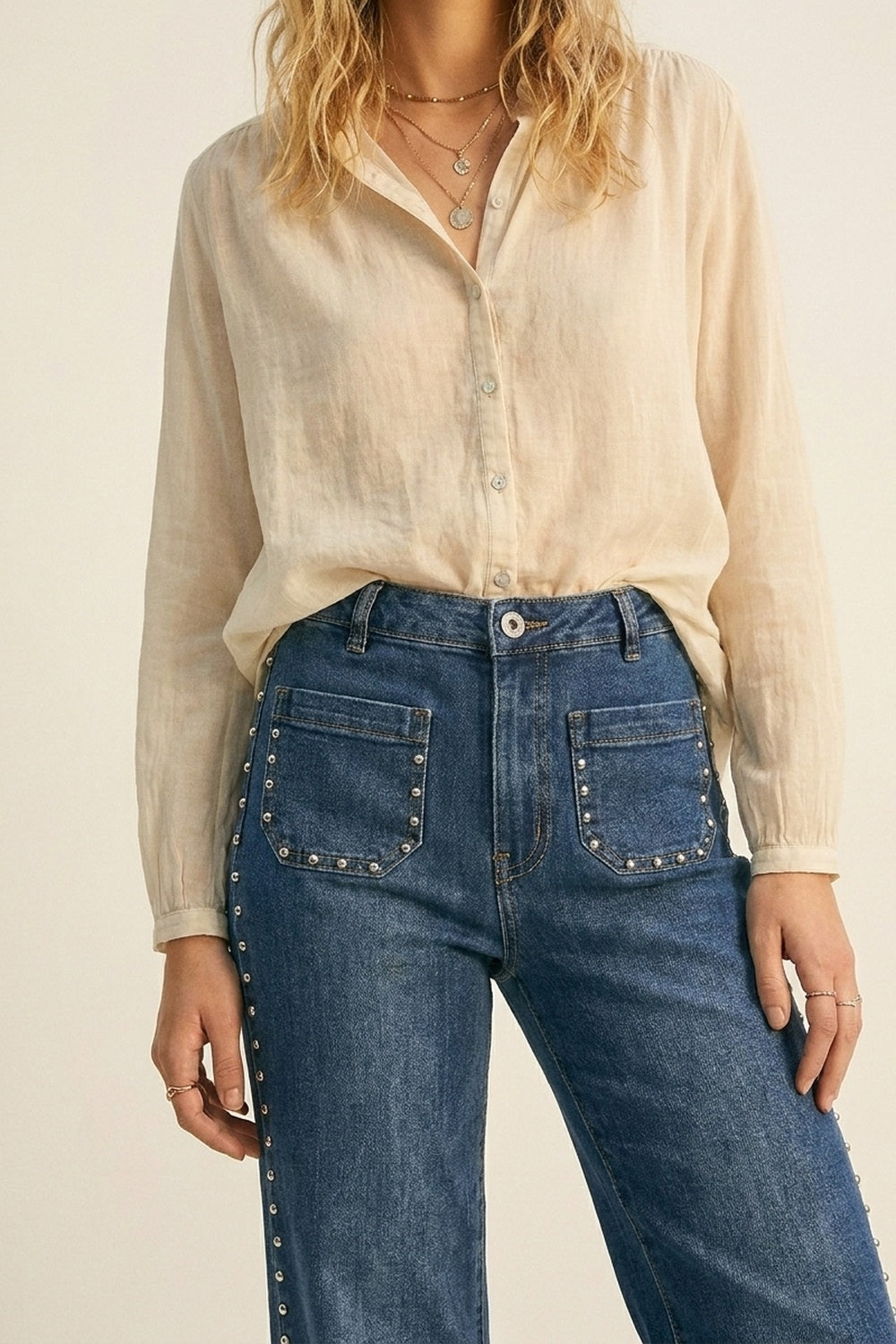 jeans di denim blu a zampa con dettagli di borchie laterali