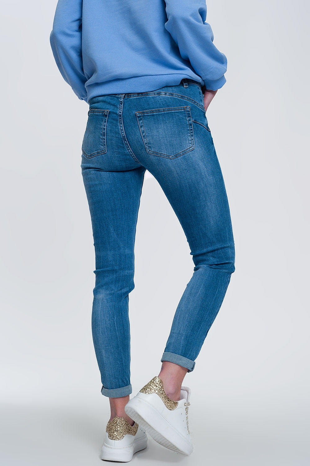 jeans skinny in denim chiaro con caviglie piegate e dettaglio strappato