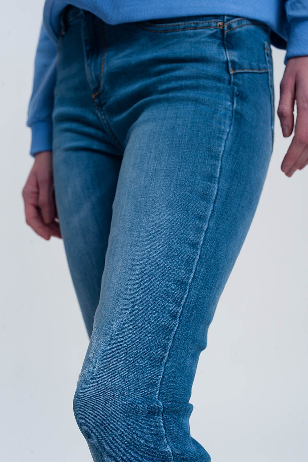 jeans skinny in denim chiaro con caviglie piegate e dettaglio strappato