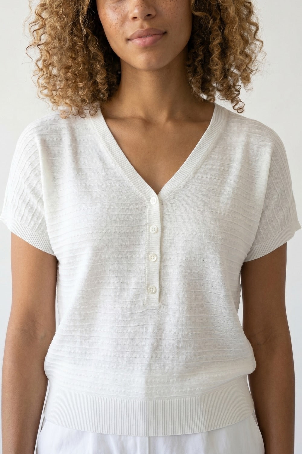 Maglione bianco a maglia con scollo a V e bottoni sul davanti