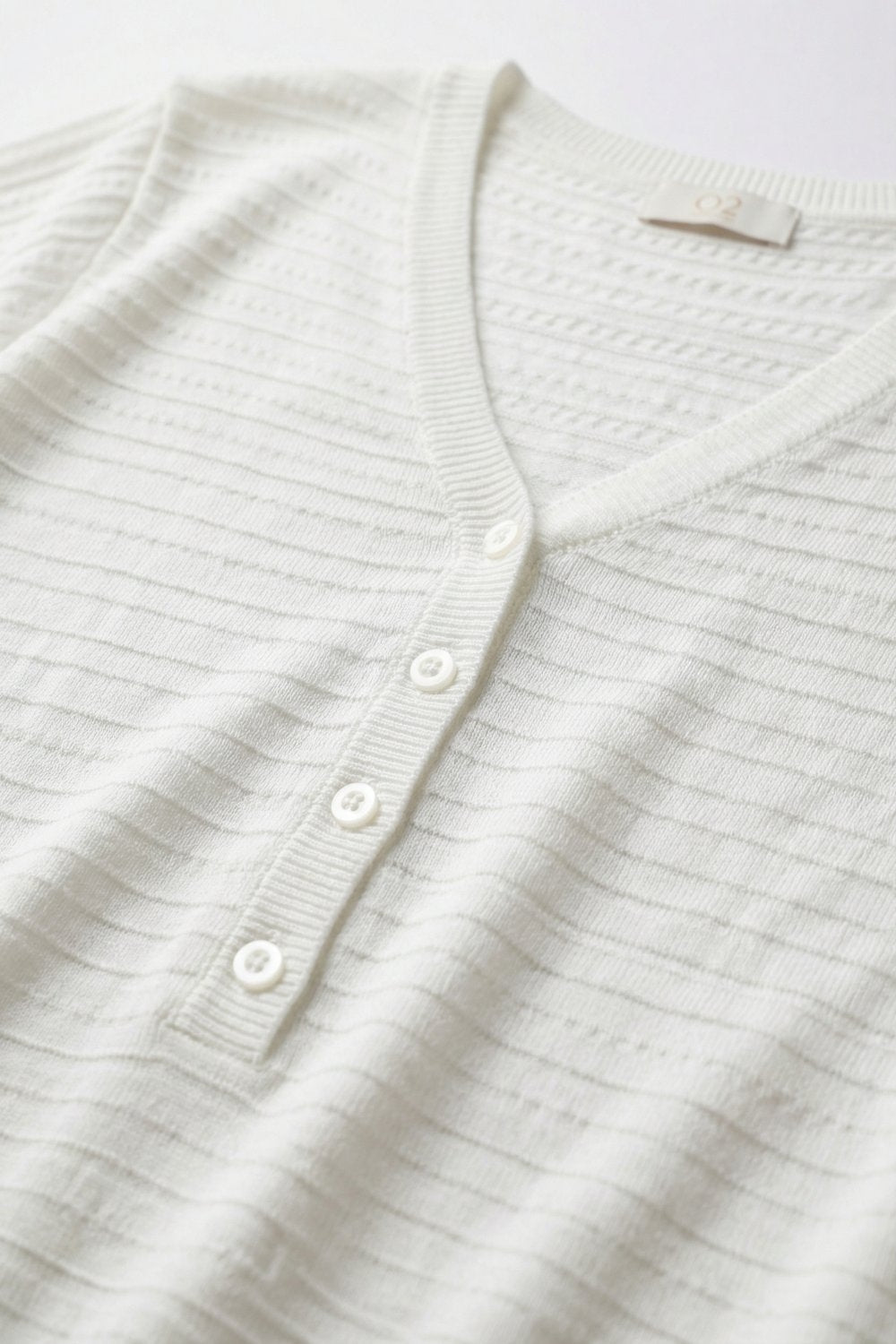 Maglione bianco a maglia con scollo a V e bottoni sul davanti