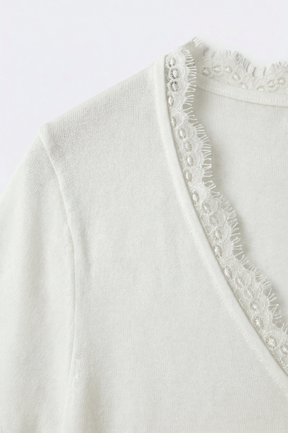 Maglione in maglia fine e morbida con scollo a V e bordo in pizzo in bianco