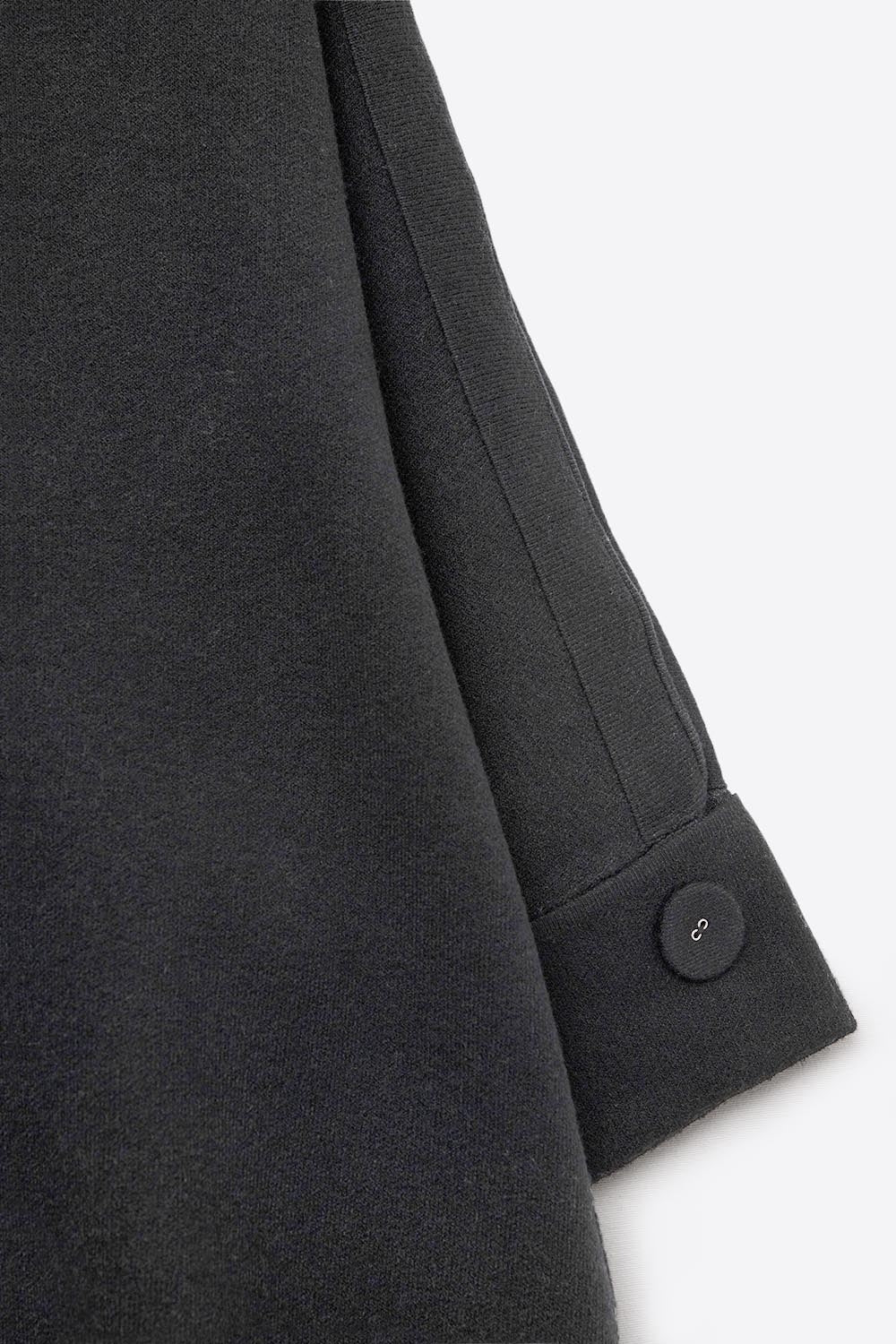 Maglione nero in maglia con maniche e dettagli sui bottoni