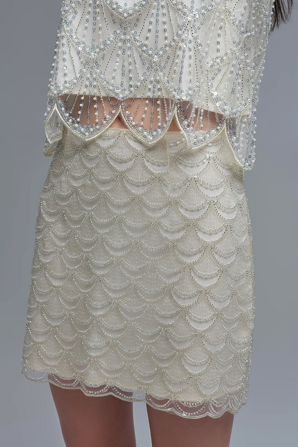 Minigonna smerlata in paillettes color crema
