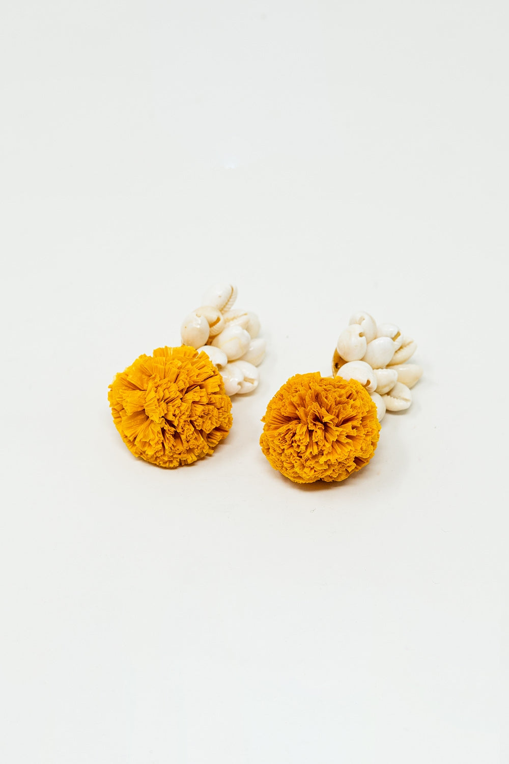 Orecchini con conchiglie color crema e pom pom gialli
