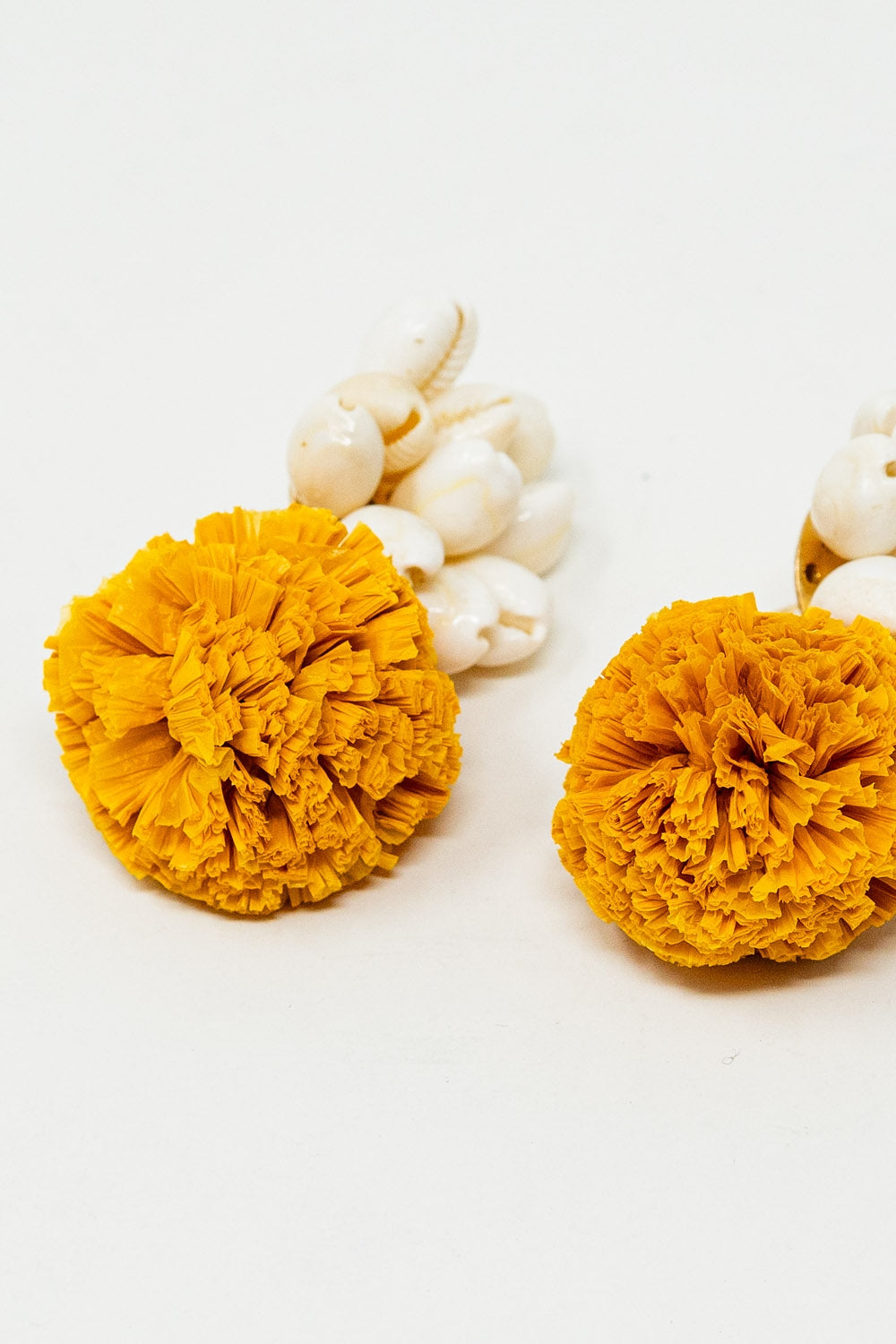 Orecchini con conchiglie color crema e pom pom gialli