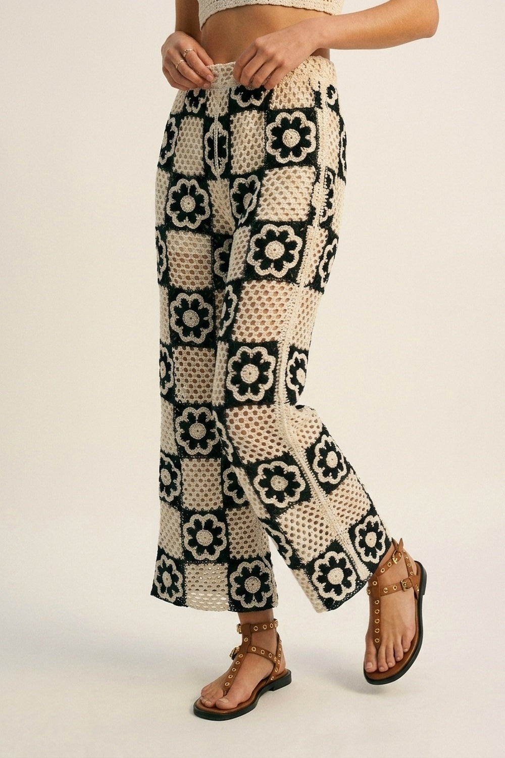 Q2 Pantaloni a zampa in crochet patchwork nero e crema con motivo floreale