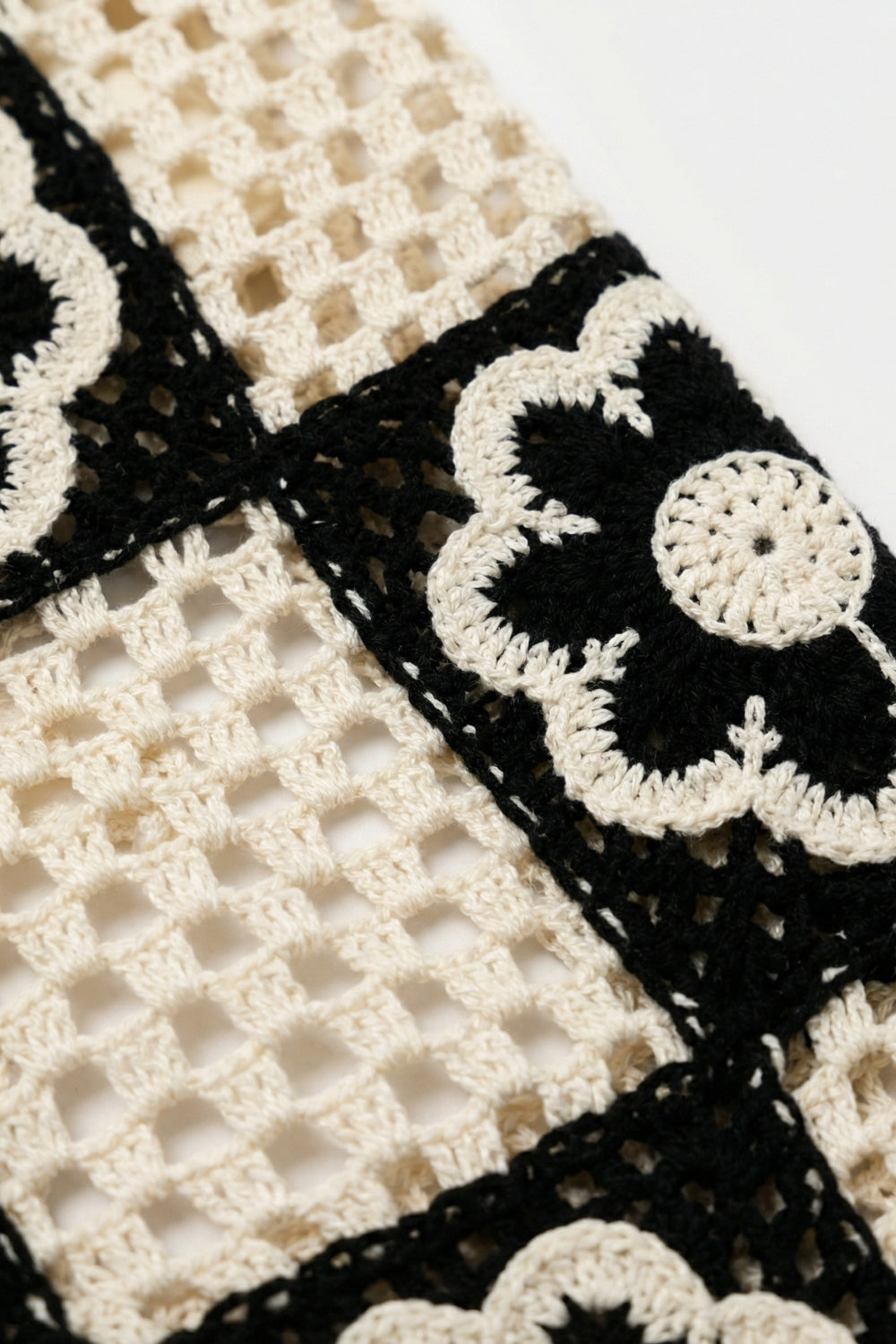 Pantaloni a zampa in crochet patchwork nero e crema con motivo floreale