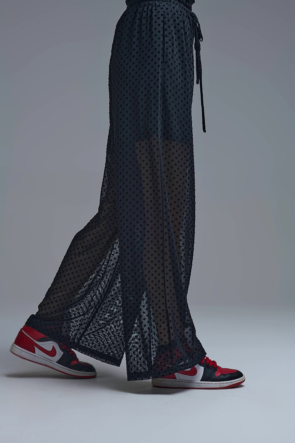 Pantaloni chic neri a pois trasparenti