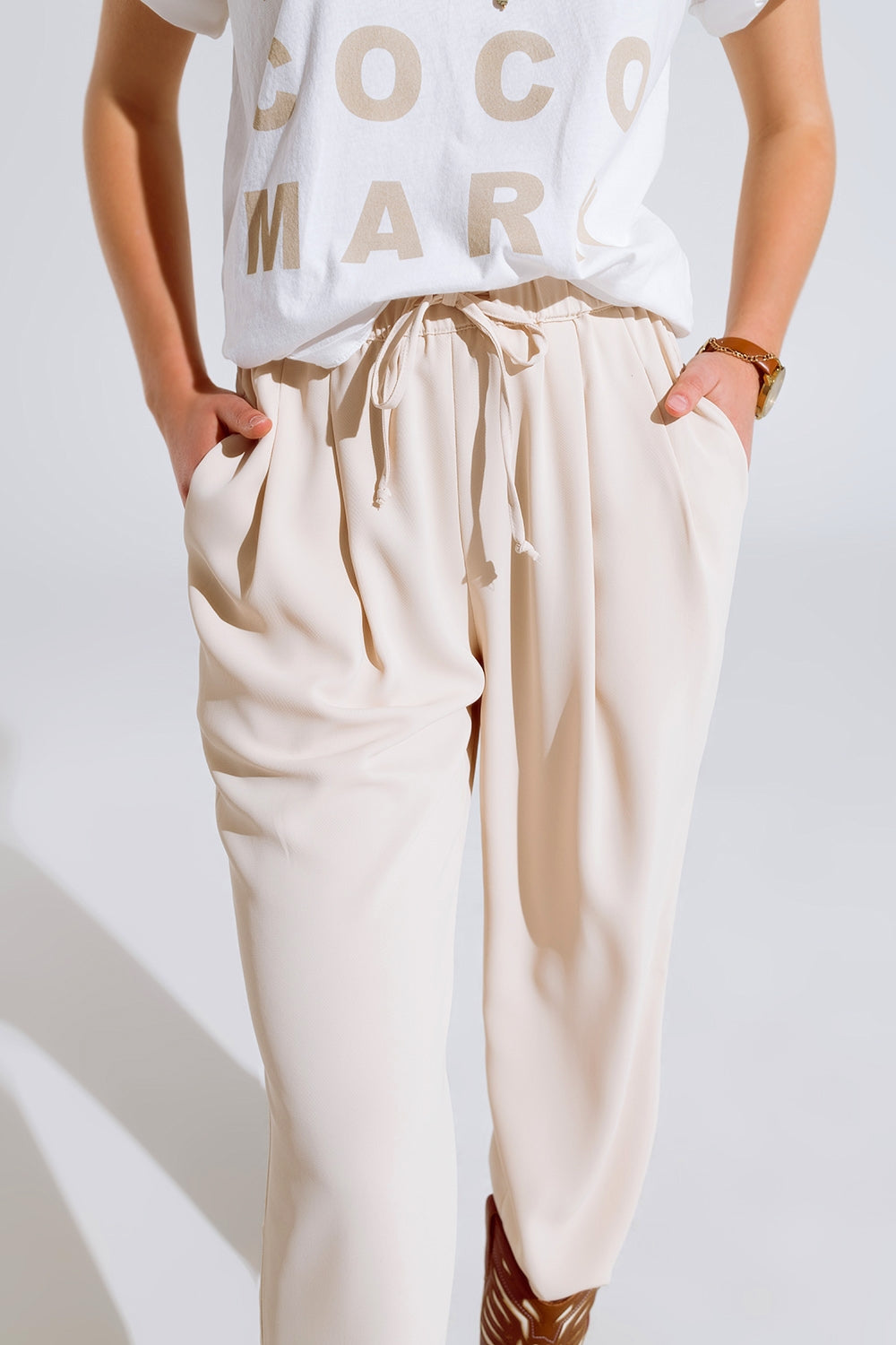 Pantaloni in beige con tasche frontali e coulisse di chiusura