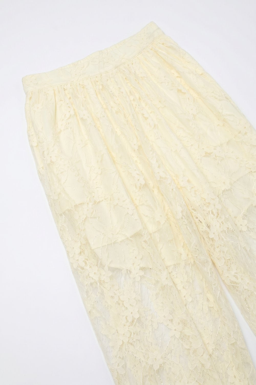 Pantaloni rilassati con orlo trasparente in pizzo floreale color crema