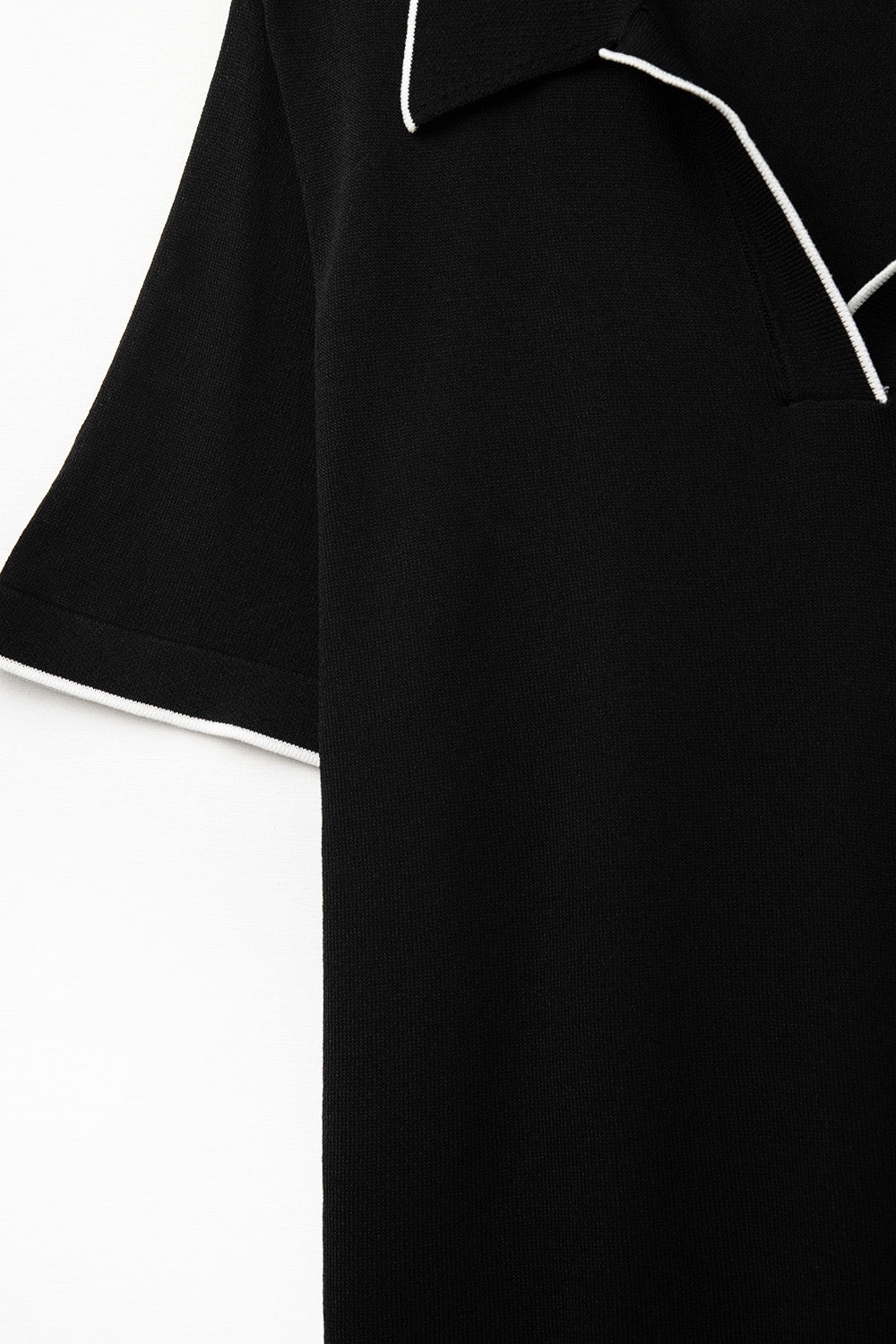Polo in maglia nera con dettagli a contrasto in bianco