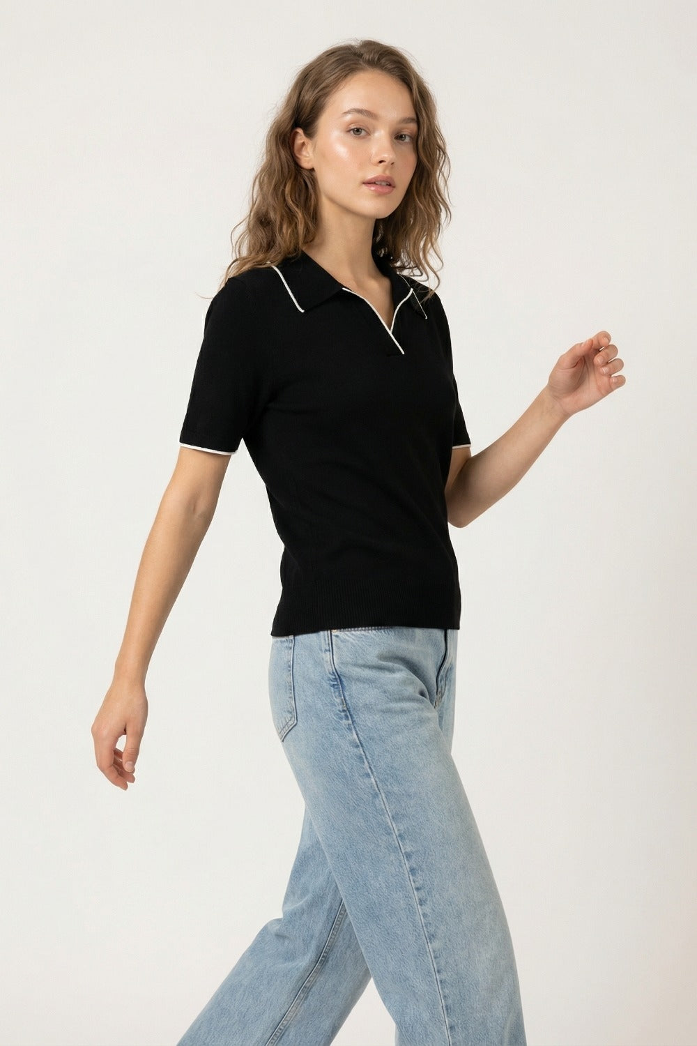 Polo in maglia nera con dettagli a contrasto in bianco