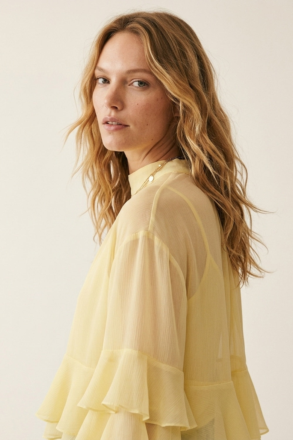 Top a collo alto con maniche svasate e arricciate in chiffon giallo