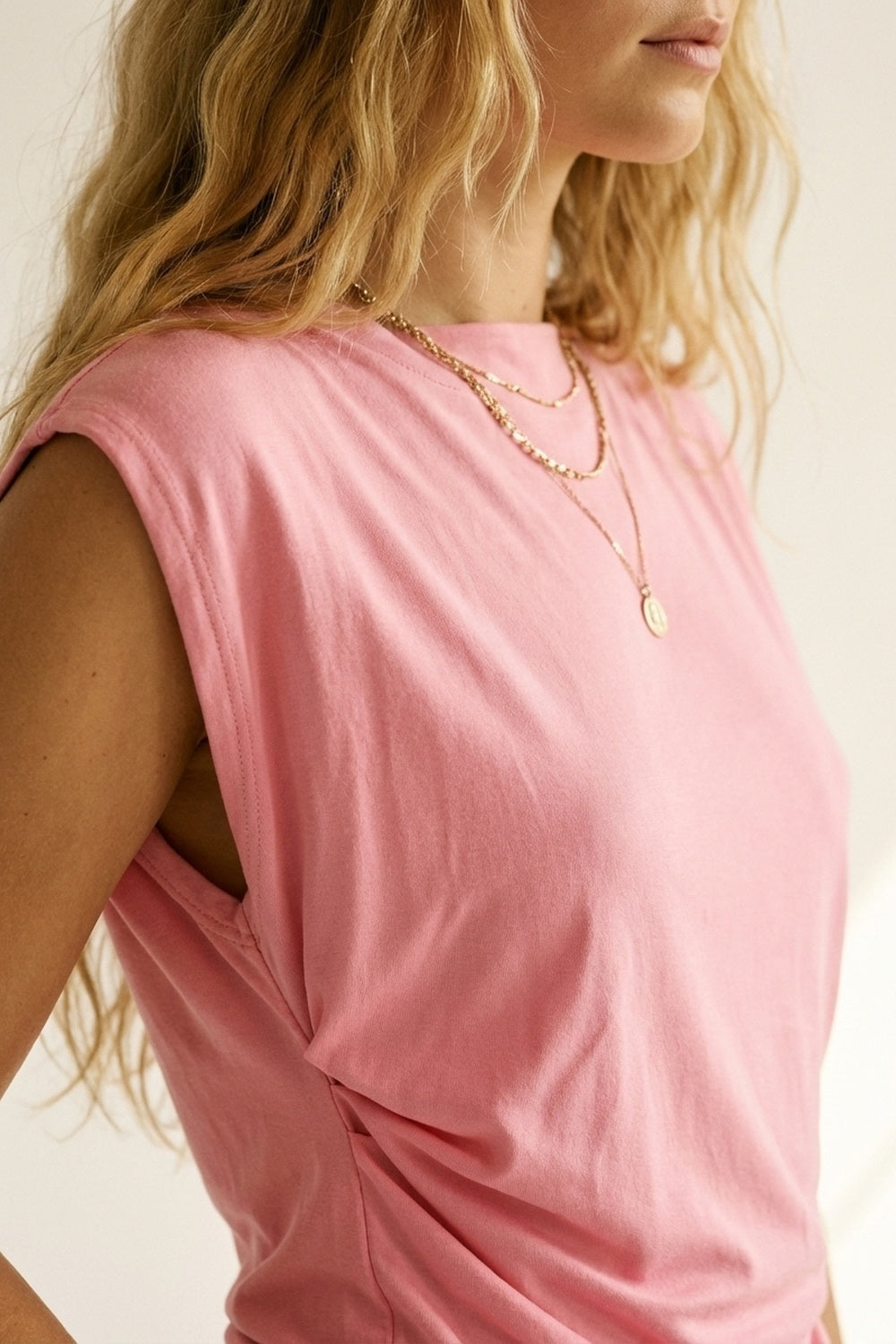 Top asimmetrico senza maniche rosa con drappeggio per donna
