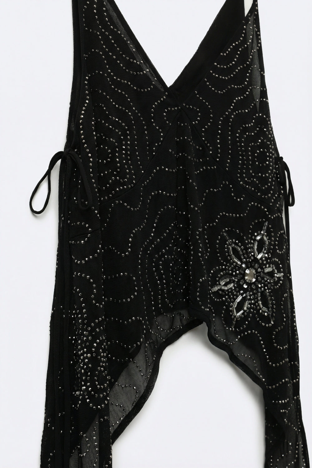 Top nero in chiffon con orlo asimmetrico e decorazioni con perline
