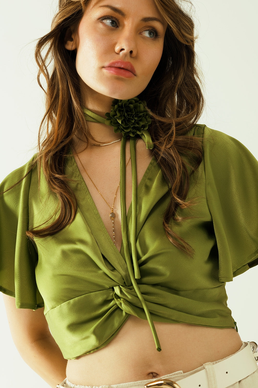 Crop top verde con scollo a V maniche corte e dettaglio floreale sul collo