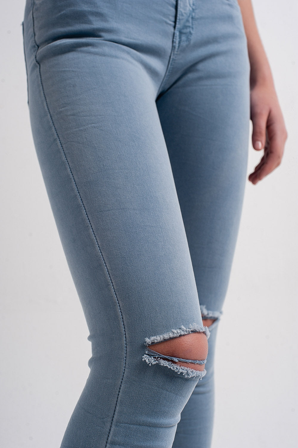 Jeans skinny blu con strappi sulle ginocchia