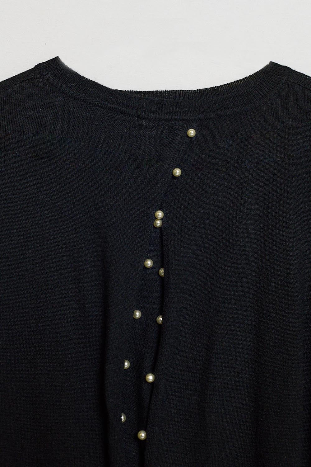 maglione nero con retro aperto e dettagli perlati
